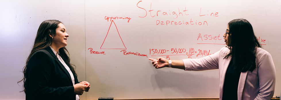 Photo of Professor explaining straight line depreciation on a whiteboard.